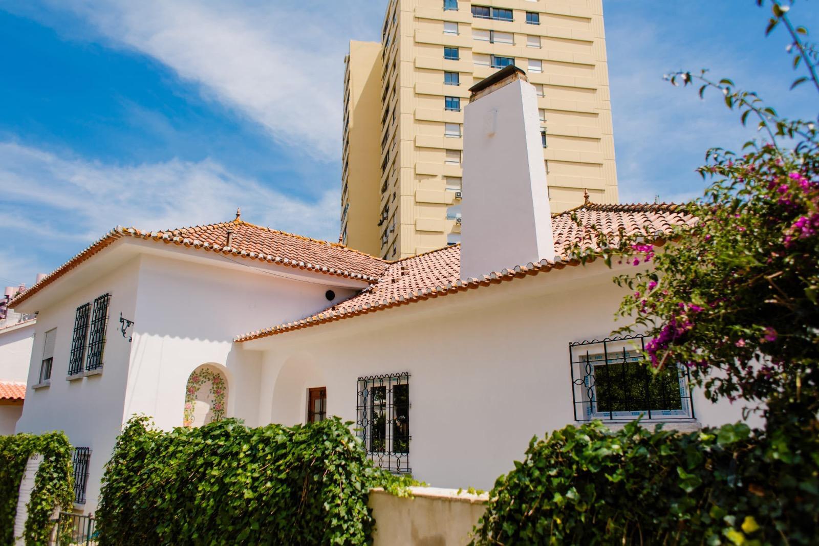 Estado inicial — fachada com reboco a destacar-se, porta de madeira original e janela com gradeamento.
