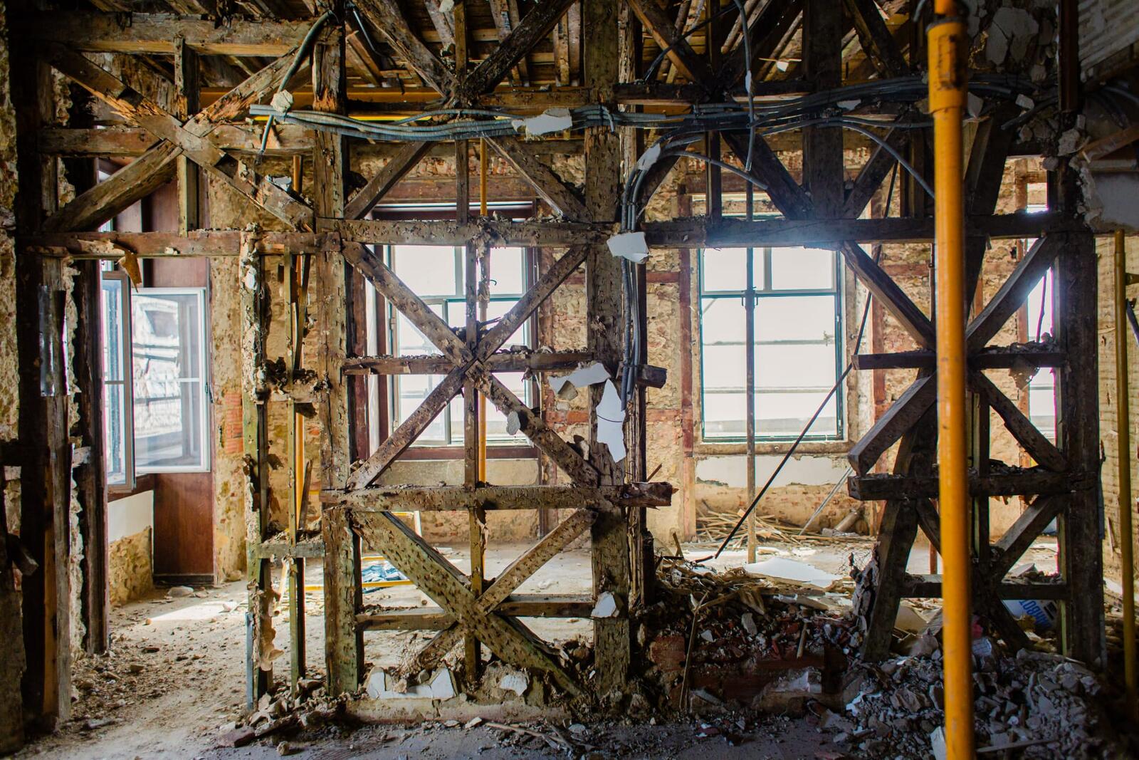 Estado inicial — interior desventrado com vigas de madeira aparentes antes da remodelação.
