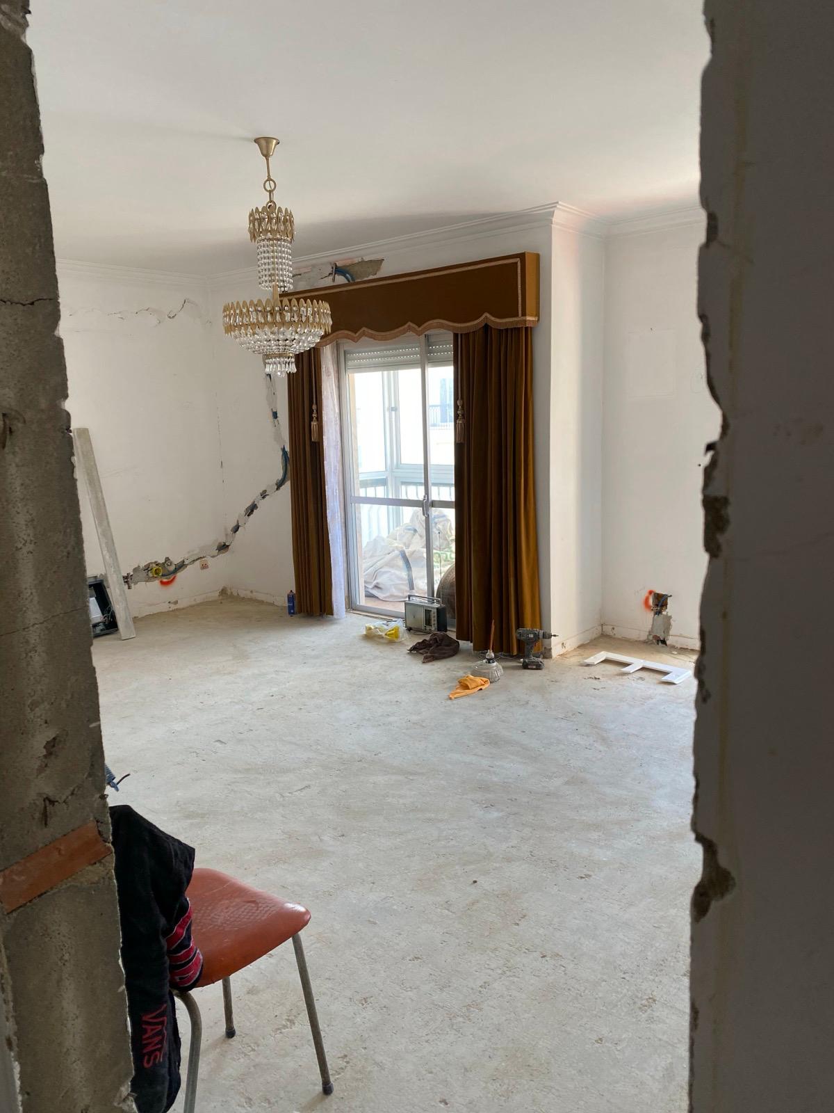 Estado inicial — sala vazia com candelabro antigo, paredes a precisar de pintura e chão por nivelar.