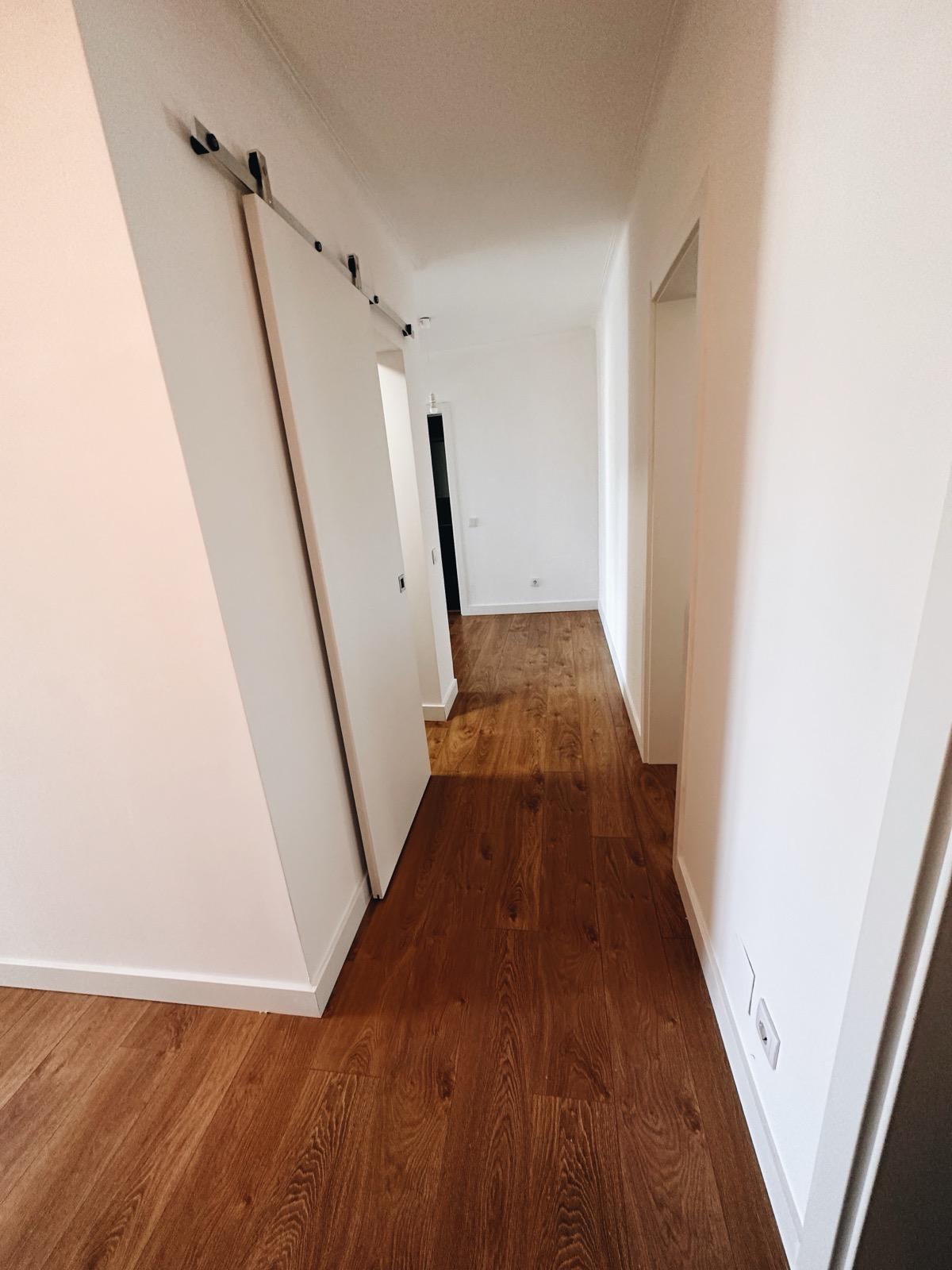 Sala ampla totalmente renovada com tecto rebaixado, iluminação encastrada e soalho flutuante.